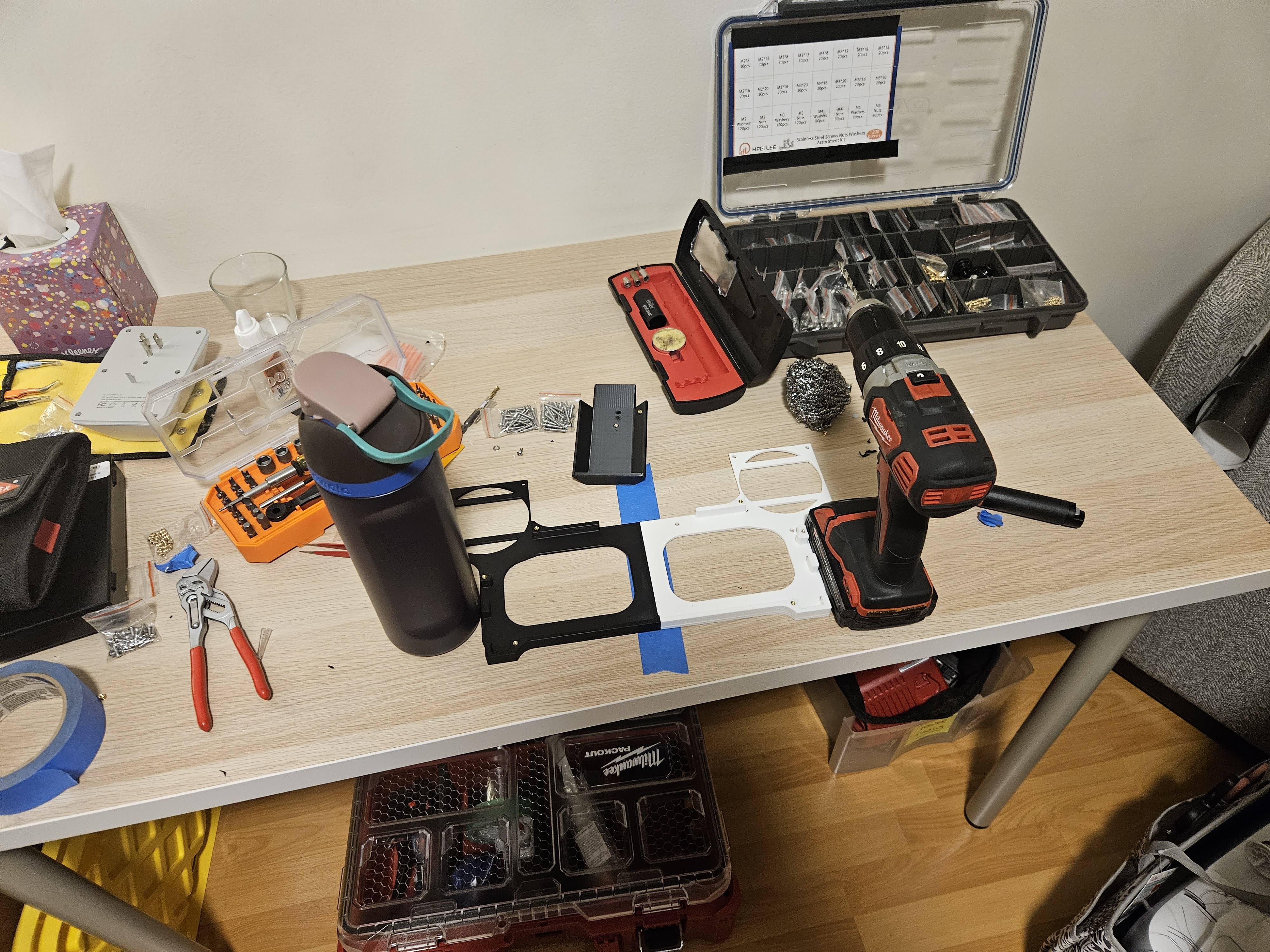 Soldering iron, inserts, and screws laid out before assembly of the Framework 16 tray.